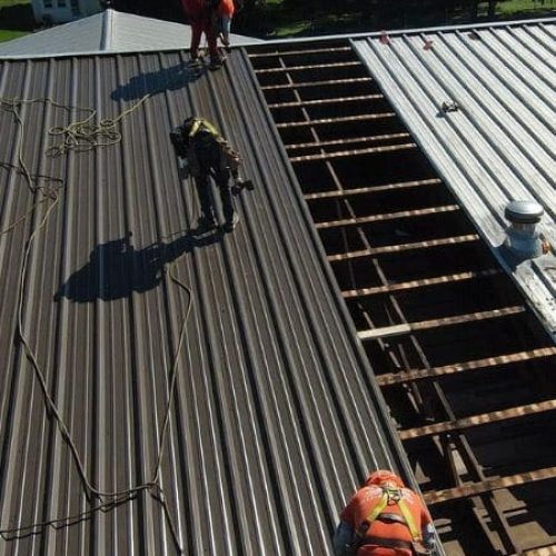 industrial roofing contractors working on metal roof