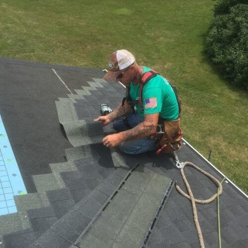 residential roofer installing asphalt shingles on home